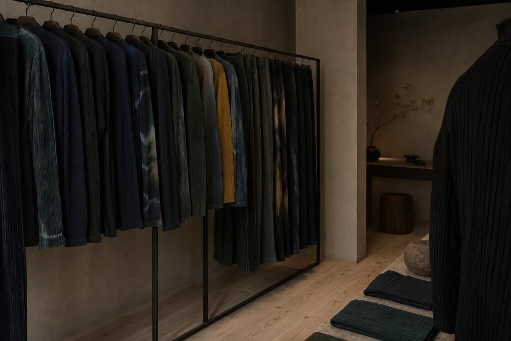黒、緑、紺、からし色のプリーツの服が並ぶ、東京の小さな服の店