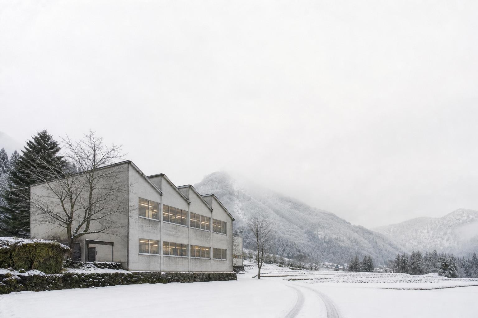 雪の山あいに建つ、のこぎり屋根の小さな編み物工場