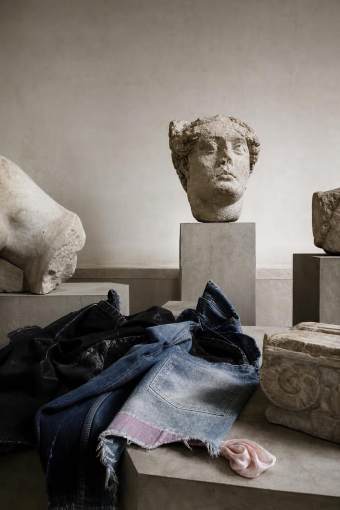石の彫刻の断片が並ぶ博物館の広間と、台に置かれたデニム