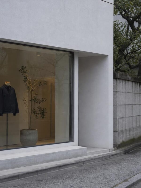 東京の静かな通りの、ガラス張りの小さな店と、無地の服を着たマネキン