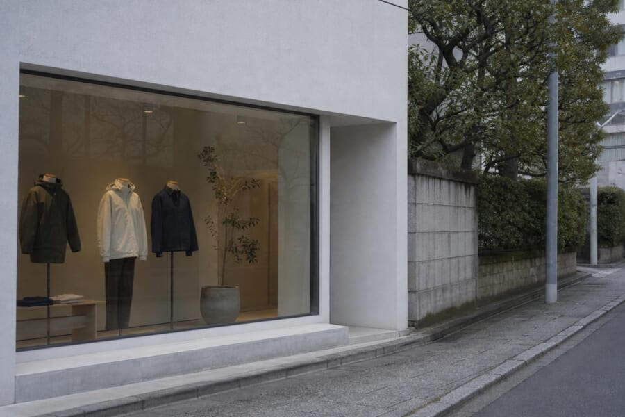 東京の静かな通りの、ガラス張りの小さな店と、無地の服を着たマネキン